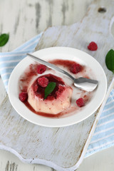 Panna Cotta with raspberry sauce, on wooden background