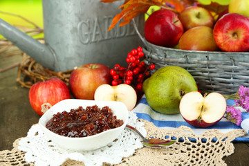 Juicy apples in basket on table on natural background