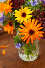 Obraz na płótnie Canvas Bouquet of autumn flowers in vase on wooden background