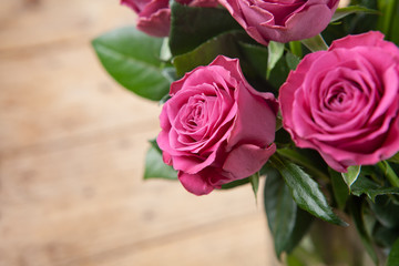 Bouquet of beautiful pink roses on wooden background.