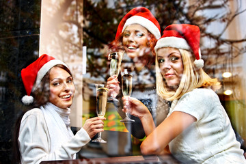 Women in santa hat drinking champagne.