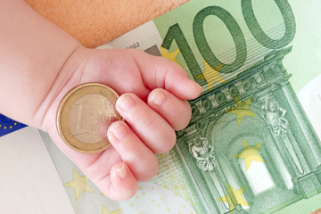 Hand von einem Baby mit Geld