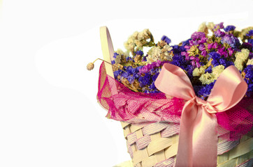 basket of flowers with pink ribbon isolated on white