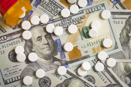 Medicine Pills Scattered on Newly Designed One Hundred Dollar Bi