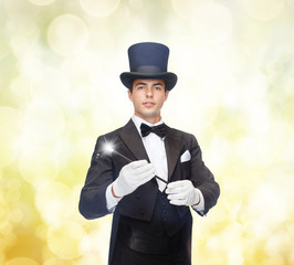 magician in top hat with magic wand showing trick