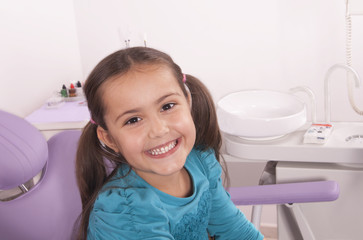 little girl smiling in the dentist chair