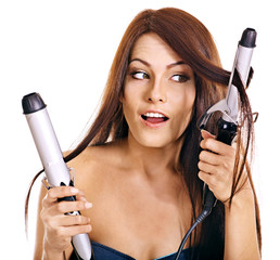 Woman holding iron curling hair.
