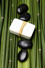 Set of stones with handmade soap on bamboo grove 