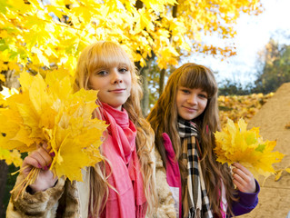 Naklejka na ściany i meble Two beautiful girls in autumn park