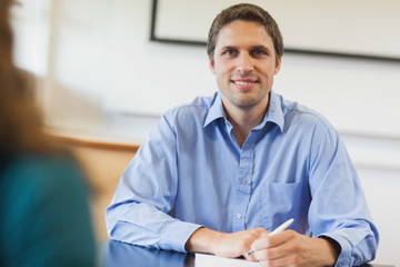 Handsome mature student sitting in classroom