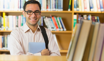 Smiling mature student with tablet PC in library