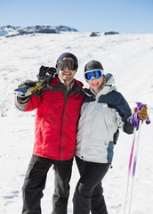 Fototapeta na wymiar Portrait of a cheerful couple with ski boards on snow