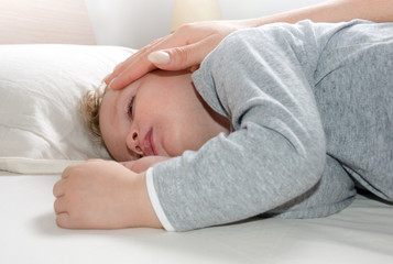 little blond boy sleeping on his bed relaxed
