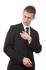 Young businessman undusting his suit