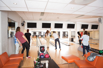 Young Friends Bowling in Club