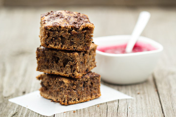 Stacked chocolate cake pieces with cherry sauce