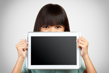 Little girl holding up a blank tablet computer obscuring the low