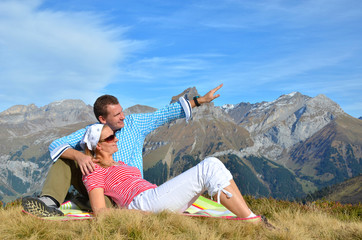 Naklejka na ściany i meble Young couple enjoying Alpine panorama. Switzerland