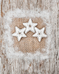 Fototapeta na wymiar Star shapes and burlap textile on the old wood