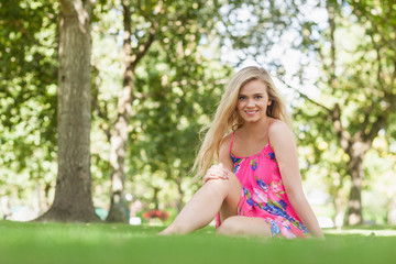 Naklejka premium Content blonde woman sitting in a park