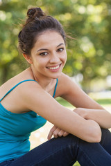 Beautiful young woman sitting on a lawn