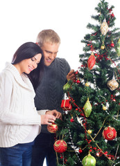 A couple waiting for the baby and decorating the Christmas tree