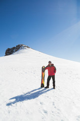 Fototapeta na wymiar Man with ski board on snow covered landscape