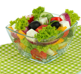 Greek salad on plate on table on white background
