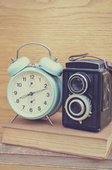 Naklejka premium Vintage camera on book and clock