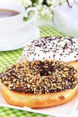 Sweet donuts with cup of tea on table close-up