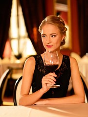 Beautiful young girl with glass of red wine 