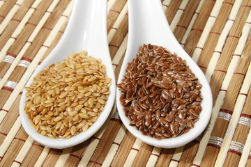 brown and golden flax seeds on ceramic spoon