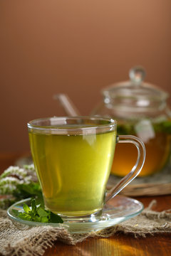 Cup and teapot of herbal tea with fresh mint flowers