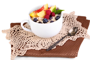 Oatmeal in cup with berries on napkins isolated on white