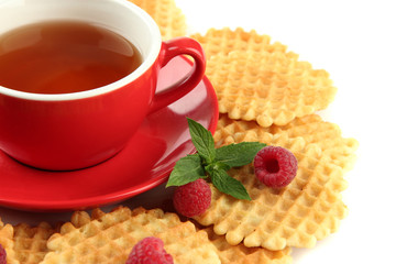 Cup of tea with cookies and raspberries close-up