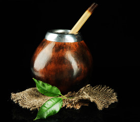 Calabash and bombilla with yerba mate isolated on black