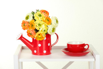 Flowers with cup of tea on white shelf on grey wall background
