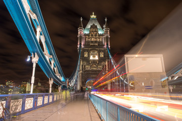 Detail of Tower Bridge in London at night with car light trail -