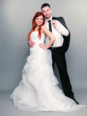 Happy married couple bride groom on gray background