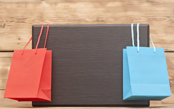 colorful shopping bags hanging on blank wood plate