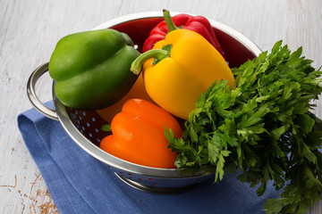 Fresh peppers in bowl on white table