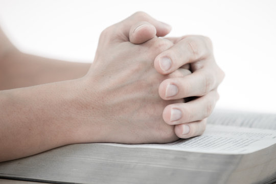 hands praying with bible