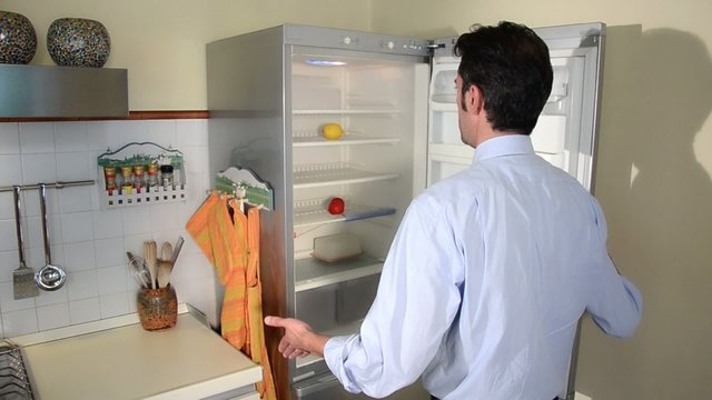 hungry man looking for food in empty refrigerator