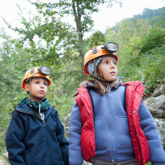 Young kids wearing helmet for cave exploration.