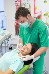 Obraz na płótnie Canvas Dentist curing a female patient