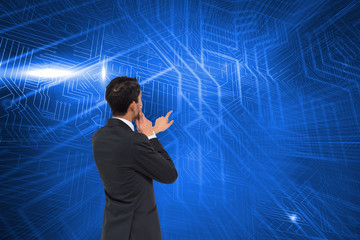 Composite image of thoughtful asian businessman pointing