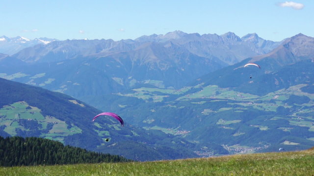 Paragliding over the mountains against clear blue sky,