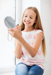 teenage girl with lip gloss and mirror