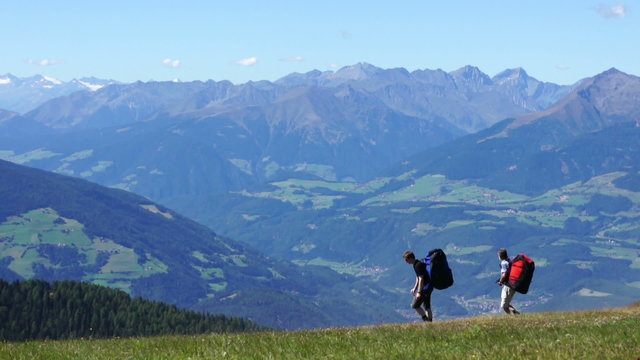 Two pilots bear backpacks with parachutes