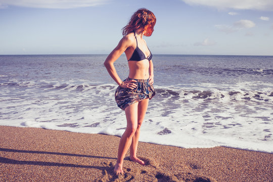 Beautiful young woman standing on the beach